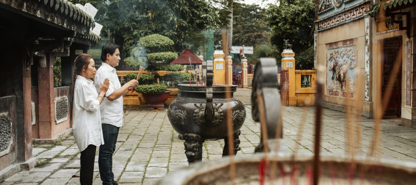 side-view-man-woman-praying-temple-with-burning-incense